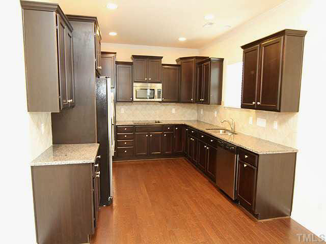 6501 Ridgemount Street Wake Forest, NC 27587 - Photo 9 of 25 Gourmet kitchen with staggered cabinets with knobs! Under cabinet lighting! Stainless Steel appliances, granite counter tops, tile backsplash and yes, the refrigerator will remain! Large pantry!
