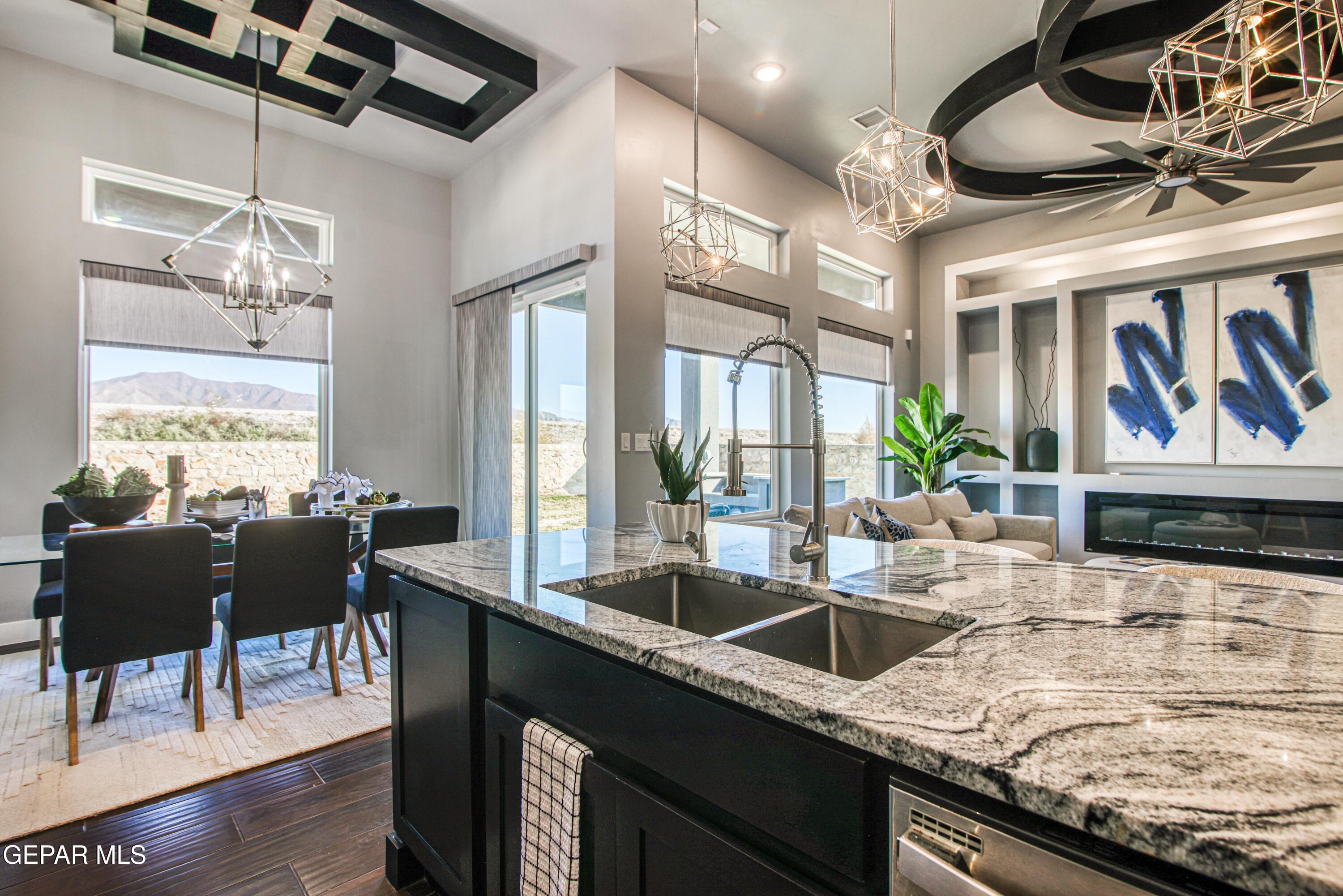 6716 Rio Haciendas El Paso, TX 79932 - Photo 19 of 65 a kitchen with stainless steel appliances granite countertop a sink a stove and a dining table with wooden floor