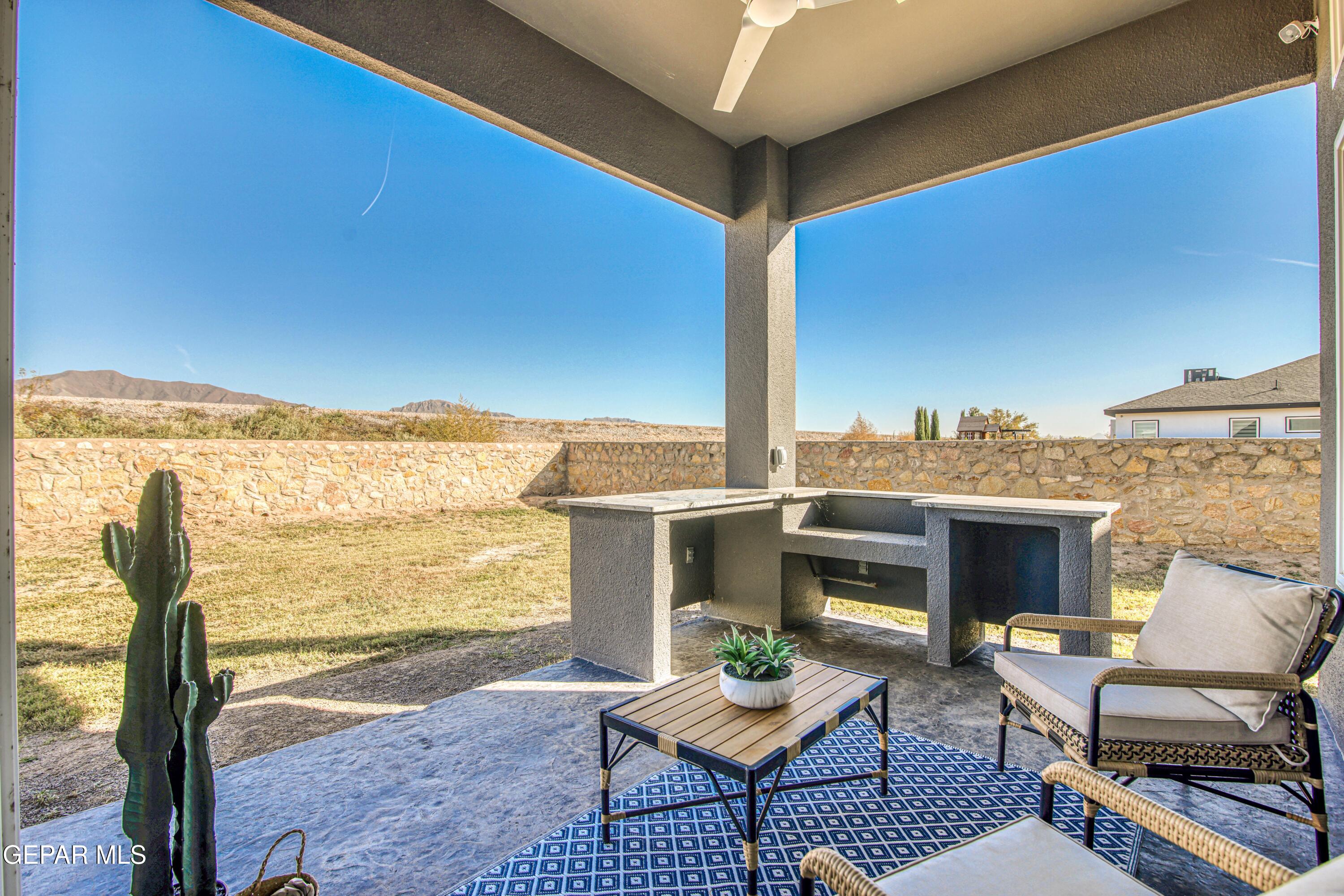 6716 Rio Haciendas El Paso, TX 79932 - Photo 59 of 65 a view of a patio with couches chairs potted plants and palm tree