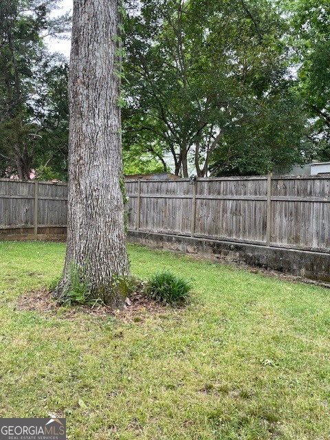 311 3rd Street Manchester, GA 31816 - Photo 52 of 62 a view of a yard with a large tree and wooden fence