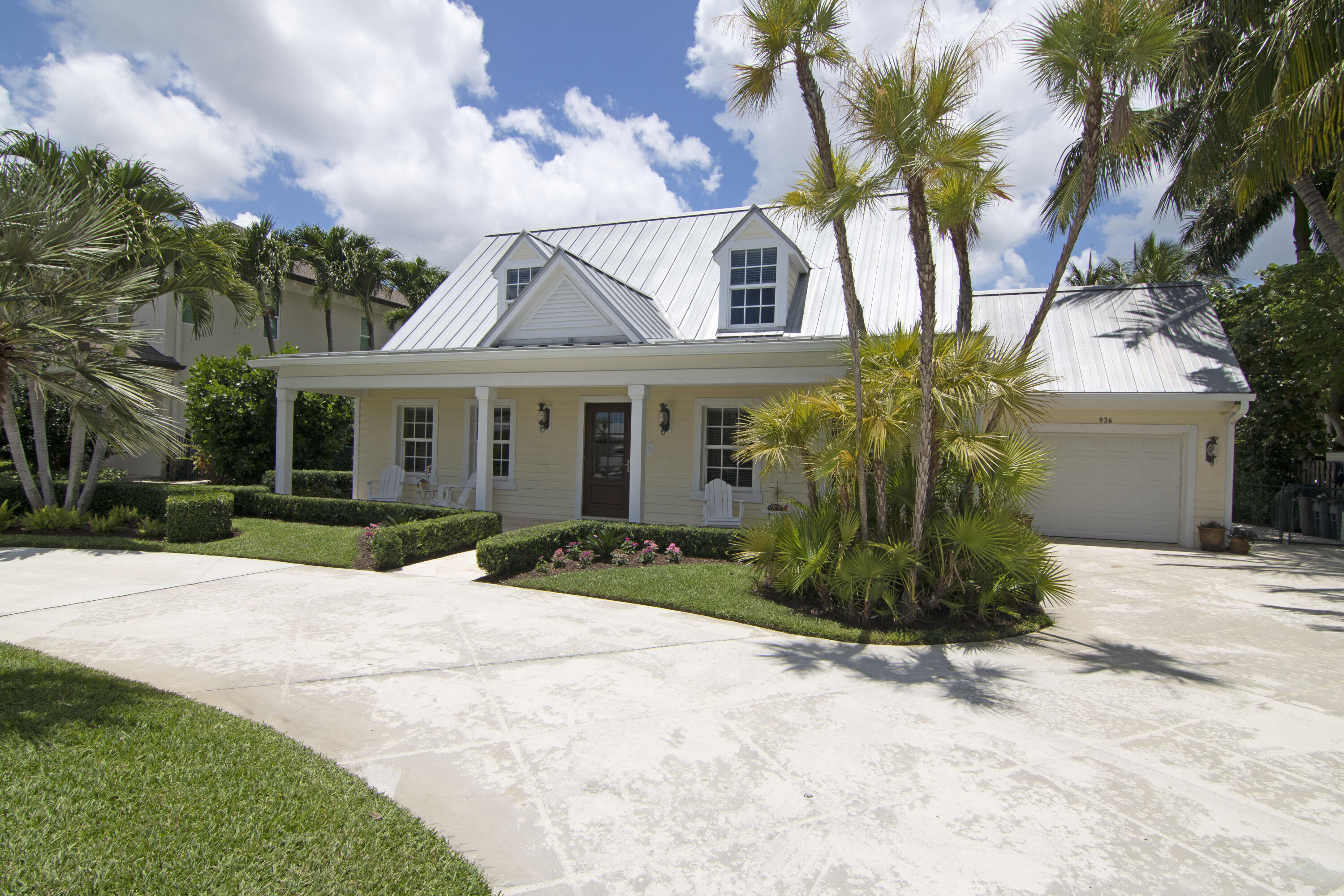 936 Dolphin Drive Jupiter, FL 33458 - Photo 45 of 72 a view of a white house with a big yard and potted plants