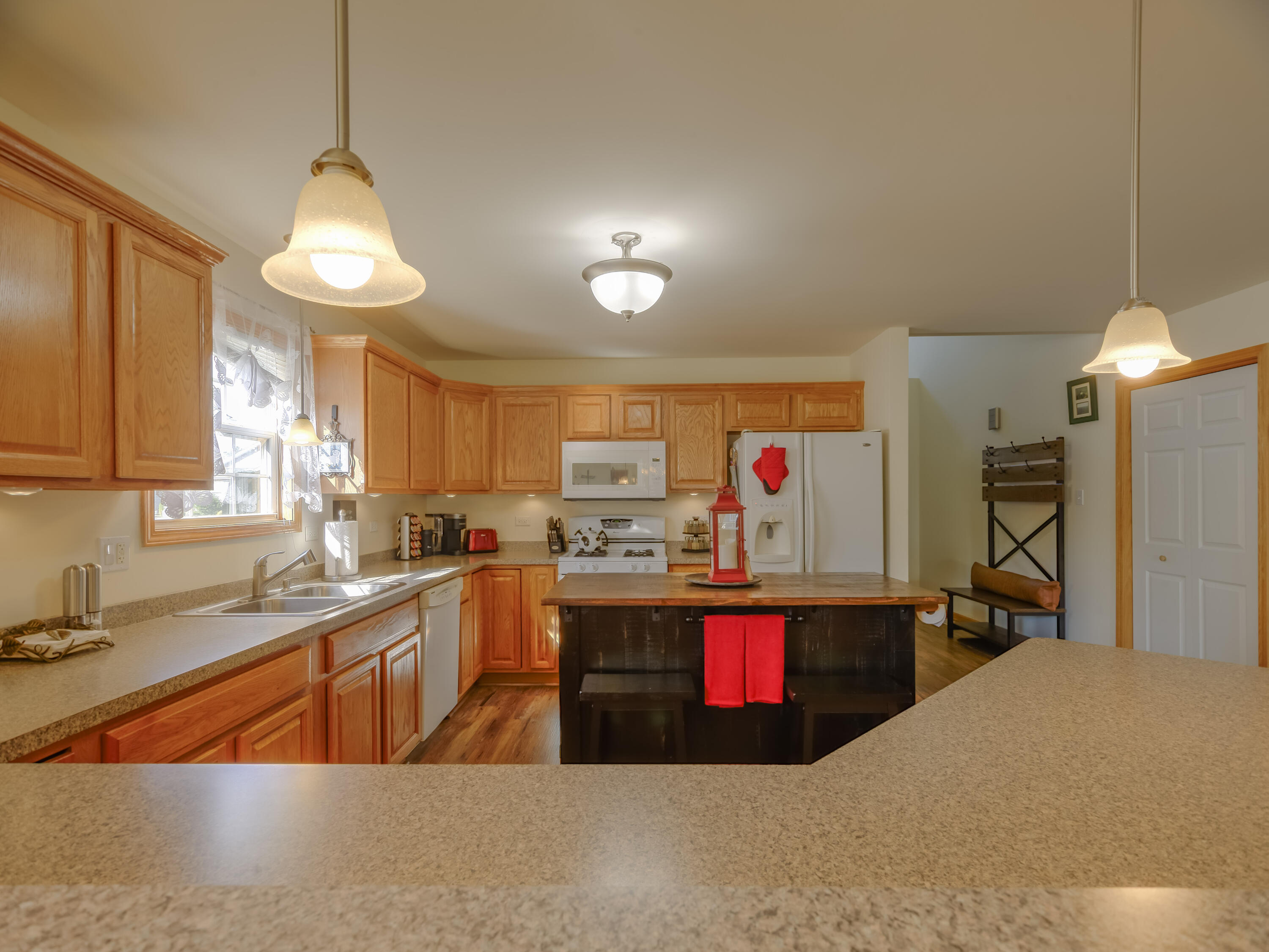 10123 Azalea Drive Crown Point, IN 46307 - Photo 12 of 32 a kitchen with stainless steel appliances granite countertop a sink dishwasher and a microwave with wooden floor