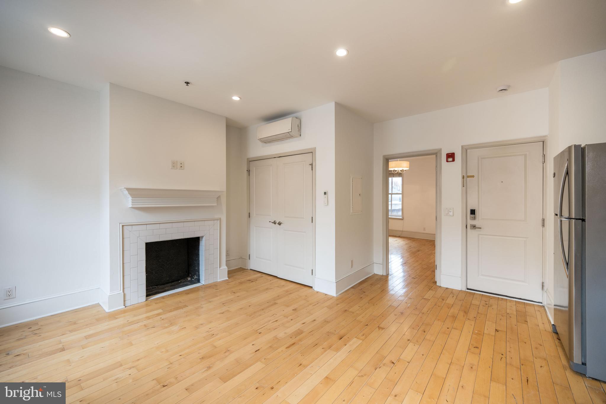 a view of empty room with wooden floor and fireplace