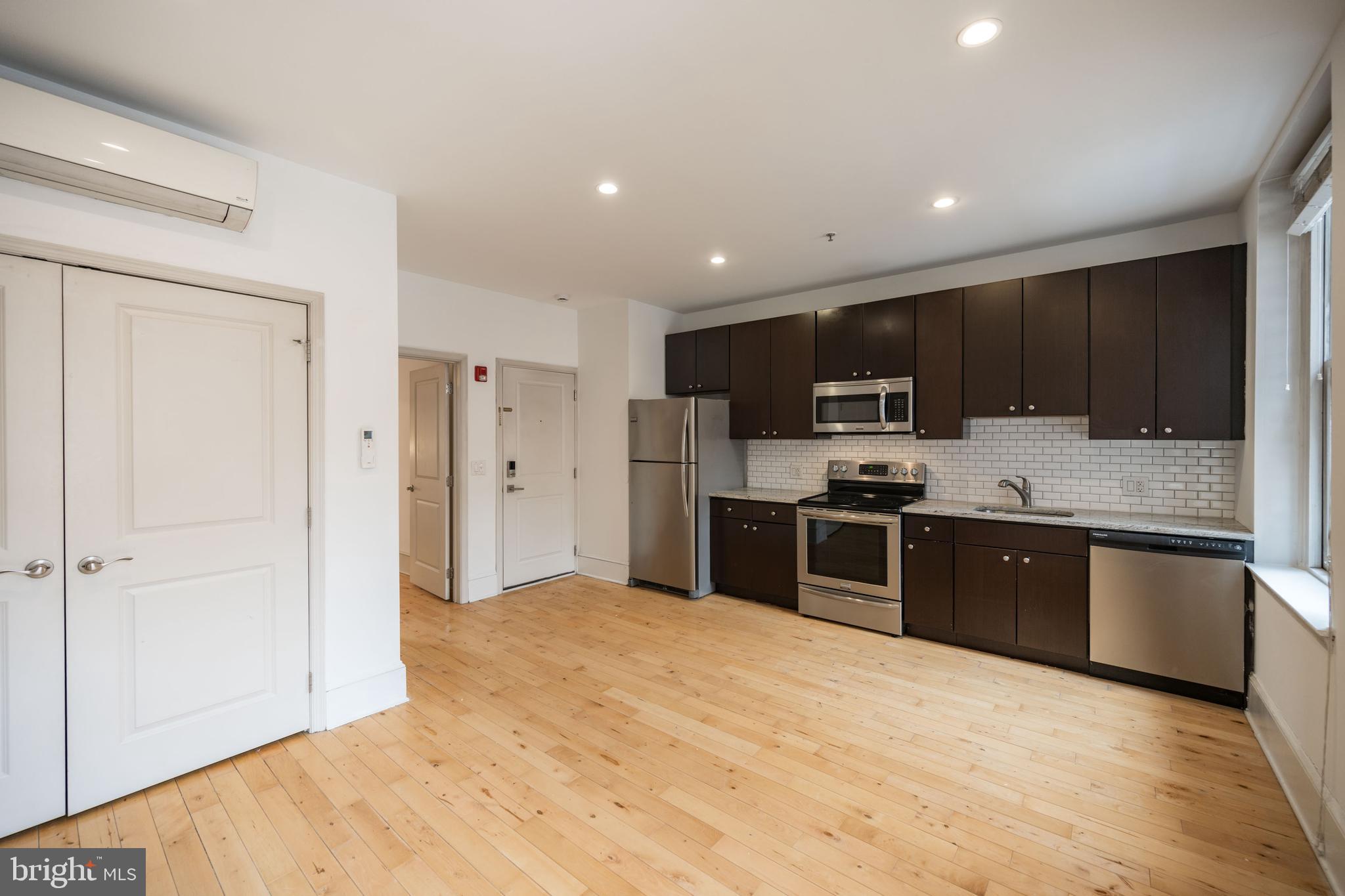 1310 Spruce Street, Unit 301 Philadelphia, PA 19107 - Photo 4 of 11 a large kitchen with a large counter top stainless steel appliances and cabinets