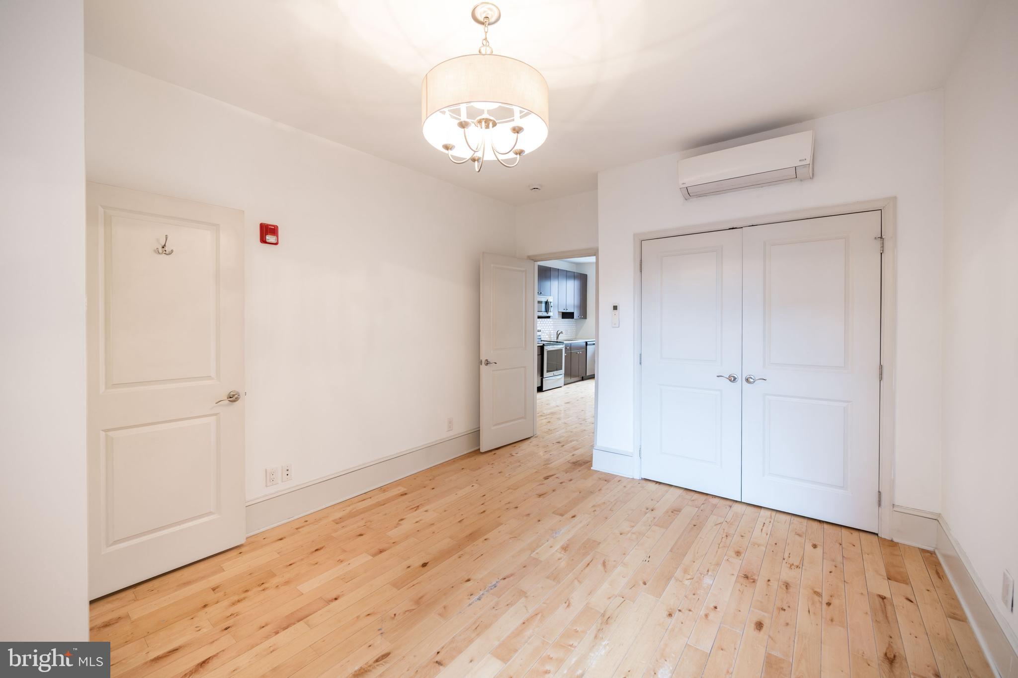 1310 Spruce Street, Unit 301 Philadelphia, PA 19107 - Photo 8 of 11 a view of a livingroom with wooden floor and a hallway