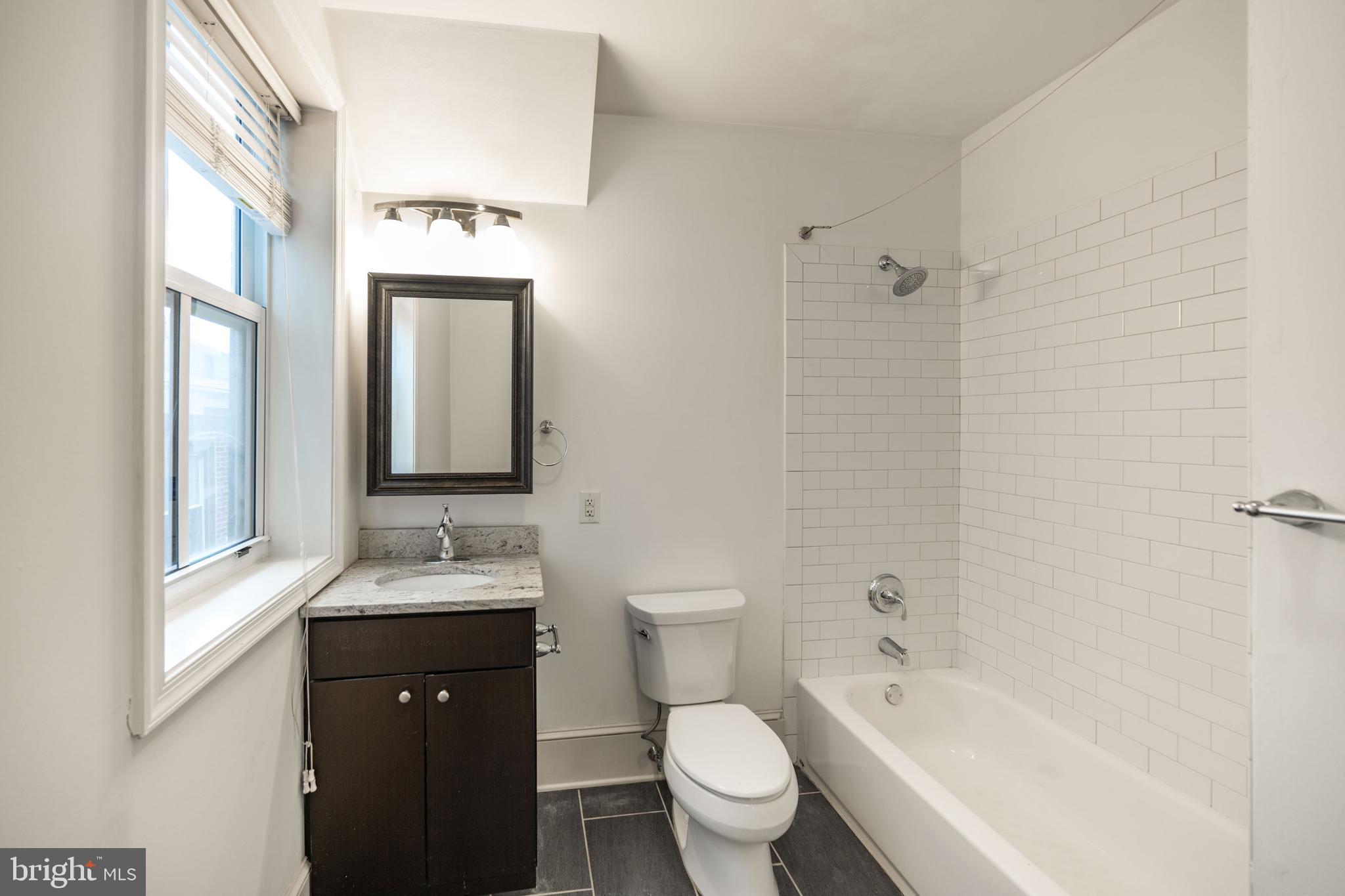 1310 Spruce Street, Unit 301 Philadelphia, PA 19107 - Photo 10 of 11 a bathroom with a bathtub shower sink mirror vanity and toilet
