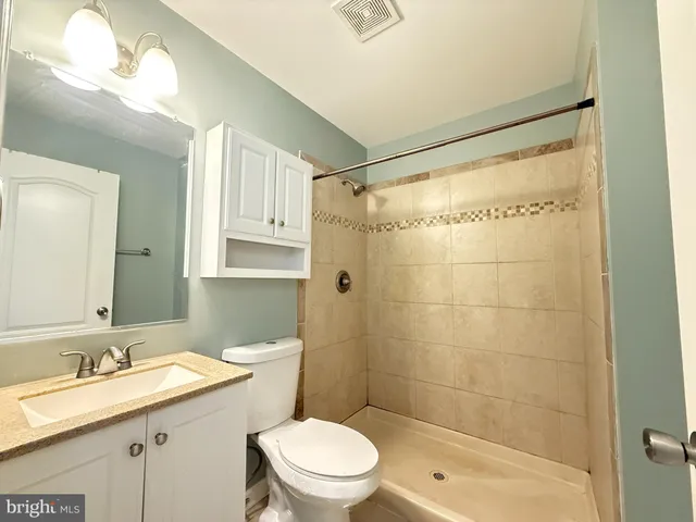 a bathroom with a granite countertop sink toilet and shower