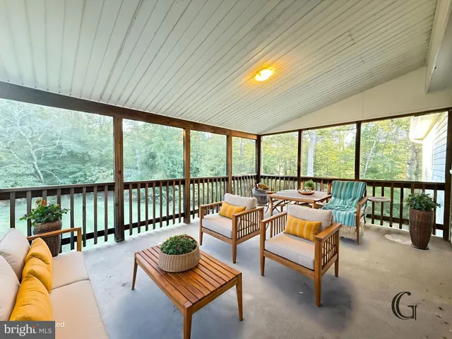 a living room with furniture and floor to ceiling windows
