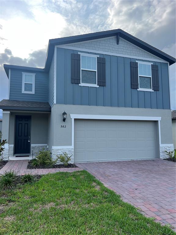 a front view of a house with a garden and garage