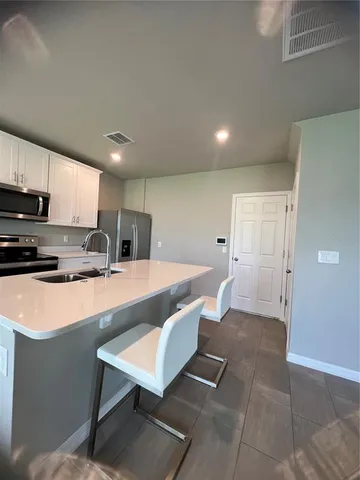 a large kitchen with a table and chairs