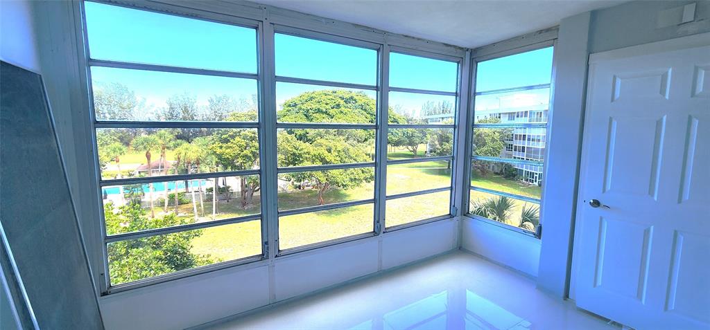 2650 South Course Drive, Unit 505 Pompano Beach, FL 33069 - Photo 21 of 42 a view of an empty room with wooden floor and windows