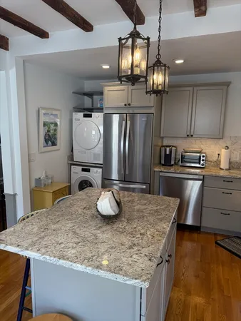 a kitchen with stainless steel appliances granite countertop a sink refrigerator and cabinets