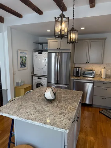 a kitchen with stainless steel appliances granite countertop a sink refrigerator and cabinets