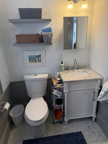 a bathroom with a toilet a sink and a mirror