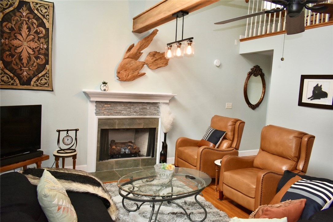 608 McKinney Way Westminster, SC 29693 - Photo 6 of 34 A comforting living room offers a stone-faced fireplace, hardwood floors, and abundant natural light.