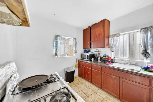 a kitchen with stainless steel appliances a sink a stove a refrigerator cabinets and dining table