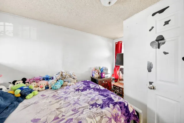 a bedroom with a bed a couch and a potted plant