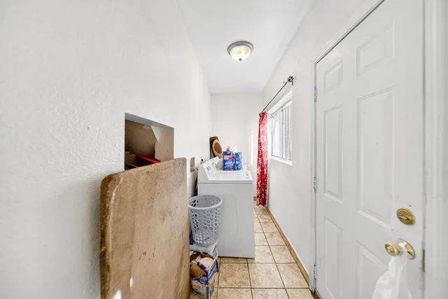 a hallway with a large mirror and a flat tv screen on dresser with wooden floor