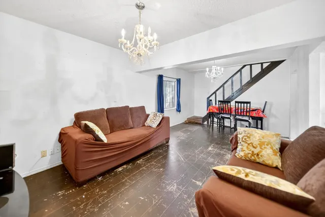 a living room with furniture a piano and a chandelier