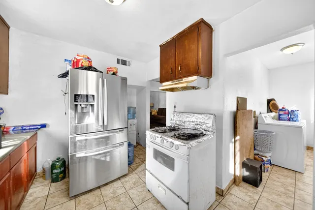 a kitchen with granite countertop a white stove top oven and refrigerator