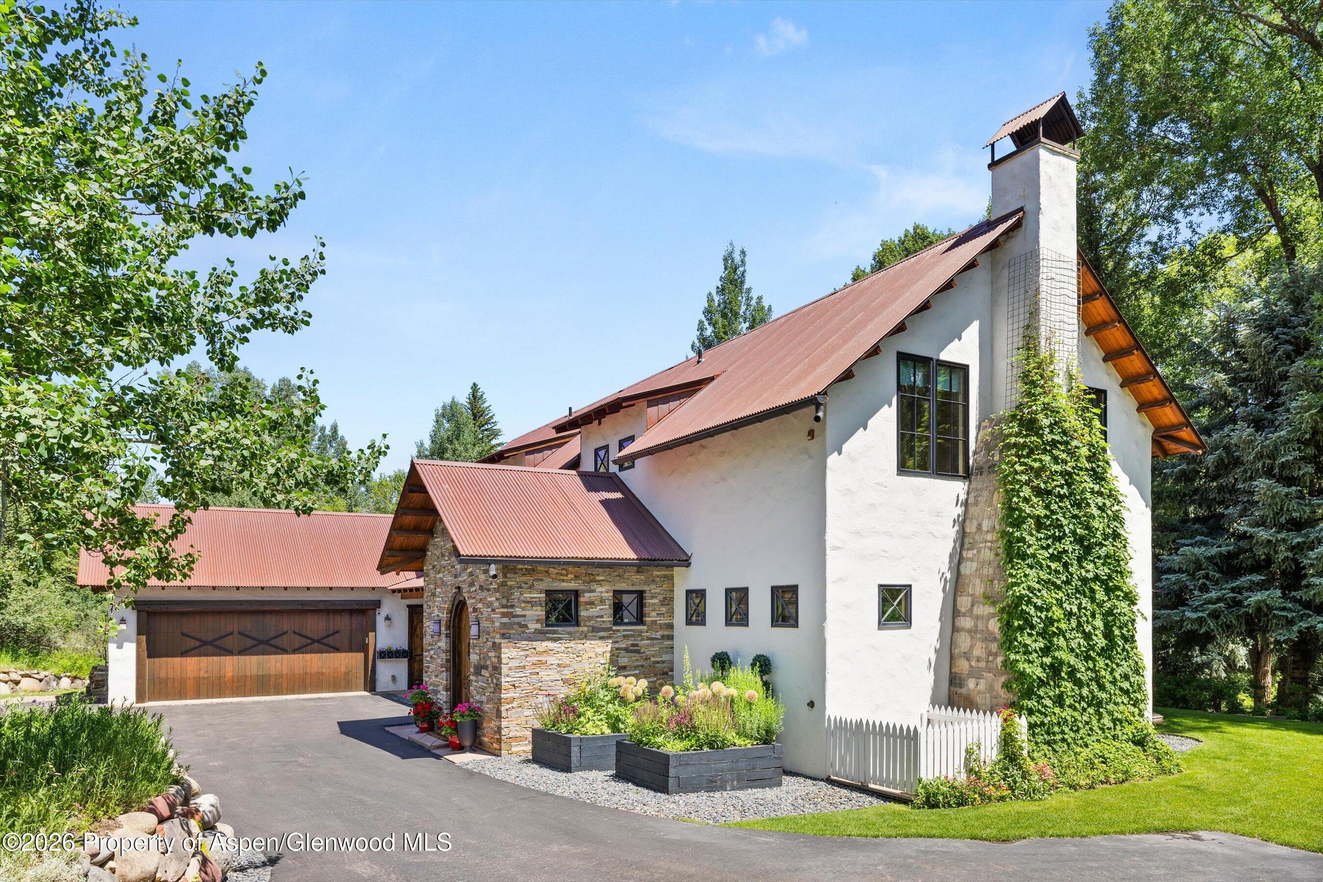 256 Twining Flats Road Aspen, CO 81611 - Photo 1 of 42 a front view of a house with a garden