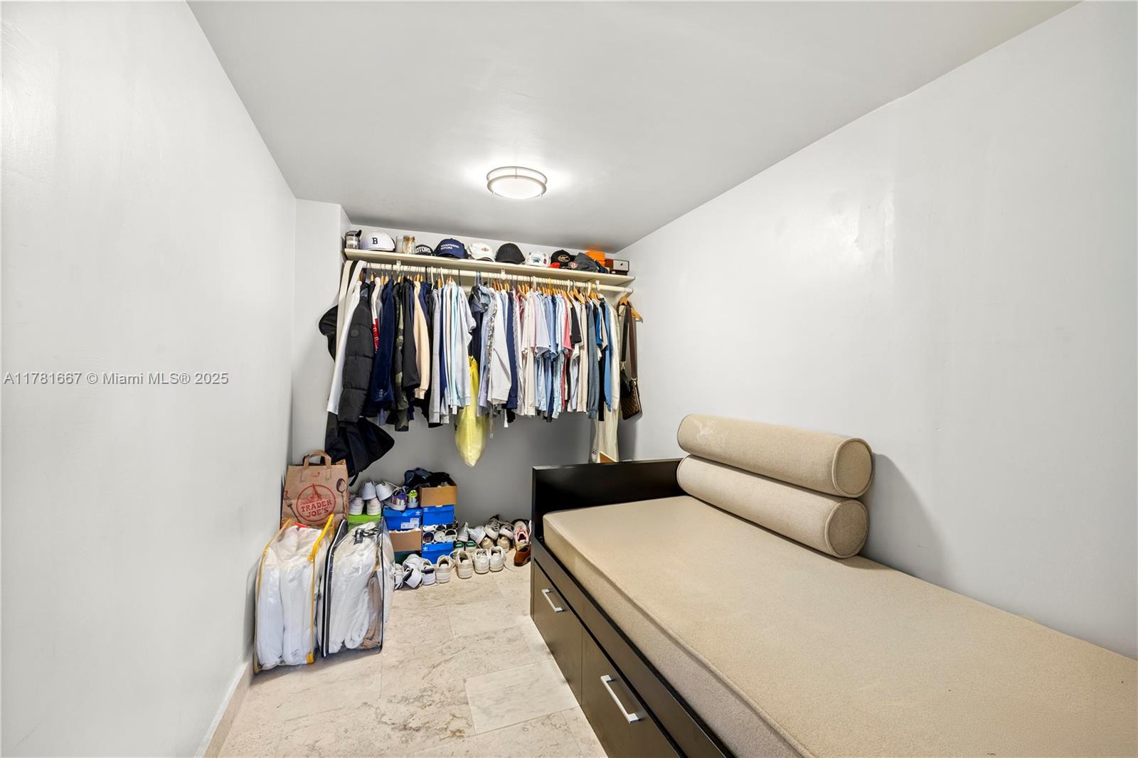 5255 Collins Avenue, Unit 11A Miami Beach, FL 33140 - Photo 13 of 15 a bed room with a bed and a walk in closet