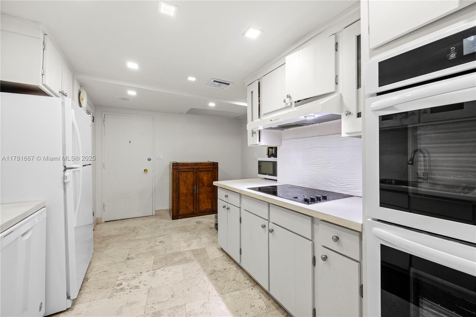 5255 Collins Avenue, Unit 11A Miami Beach, FL 33140 - Photo 10 of 15 a kitchen with a sink and refrigerator