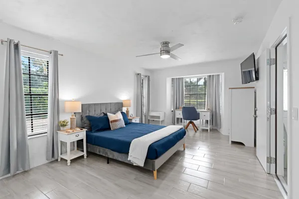 a bedroom with a bed wooden floor and window