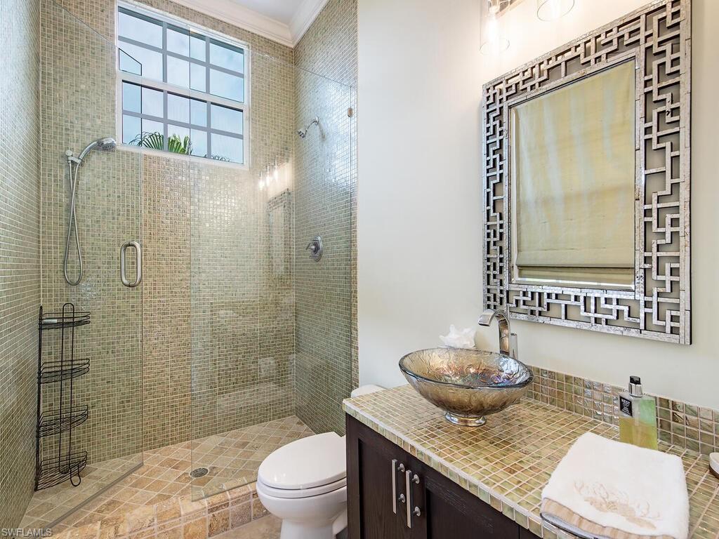 613 14th Avenue South Naples, FL 34102 - Photo 20 of 28 a bathroom with a granite countertop sink a toilet and shower