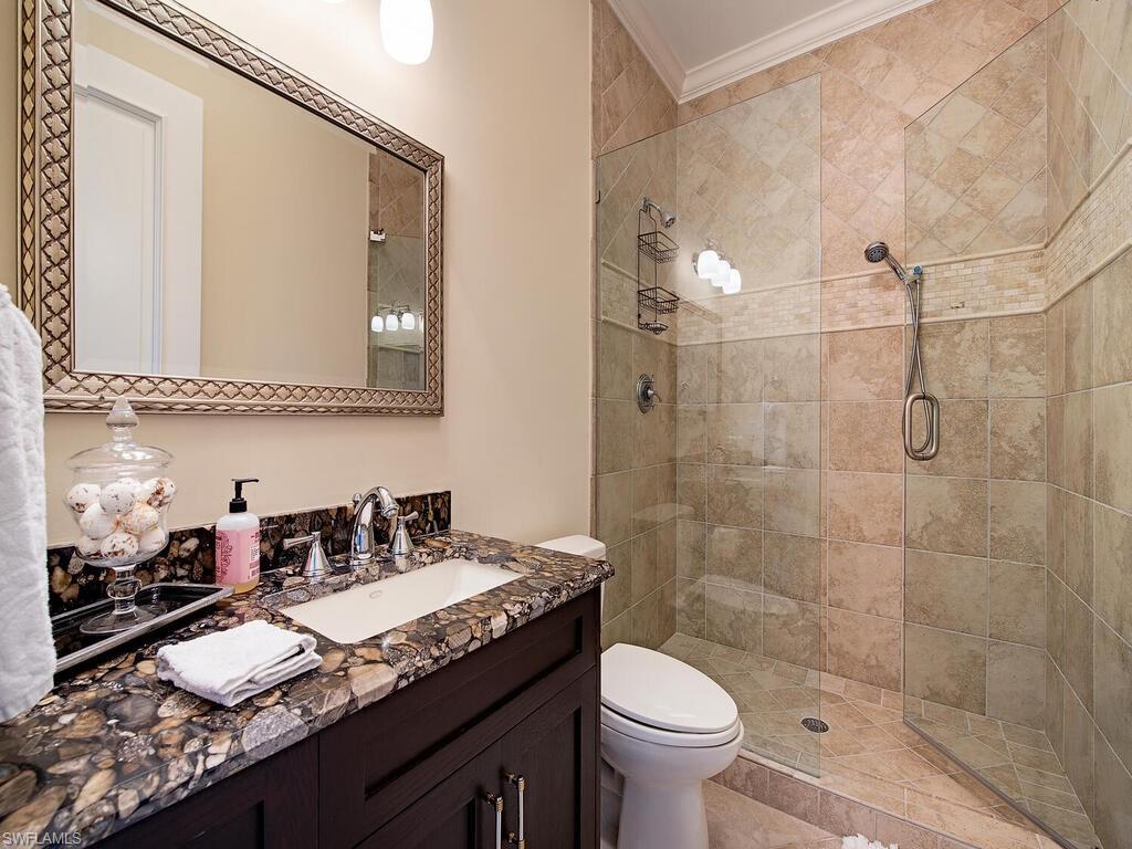 613 14th Avenue South Naples, FL 34102 - Photo 24 of 28 a bathroom with a granite countertop sink a toilet and shower
