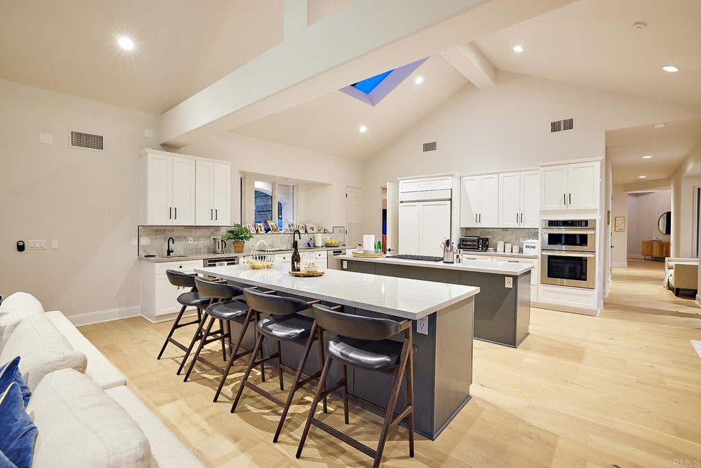 17356 Circa Oriente Rancho Santa Fe, CA 92067 - Photo 6 of 29 a kitchen with stainless steel appliances kitchen island granite countertop a table chairs sink and cabinets