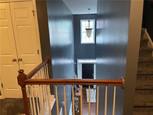 a view of staircase with railing and a mirror