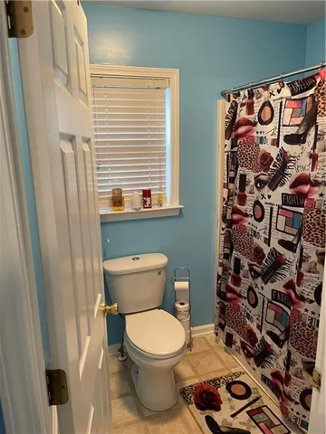 a bathroom with a toilet and a shower curtain