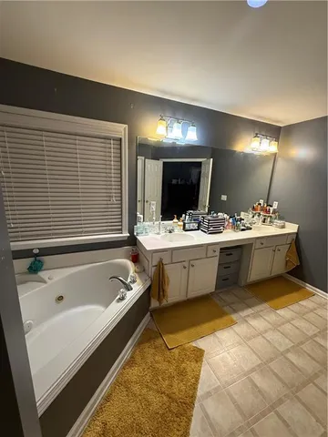 a bathroom with a tub sink and mirror