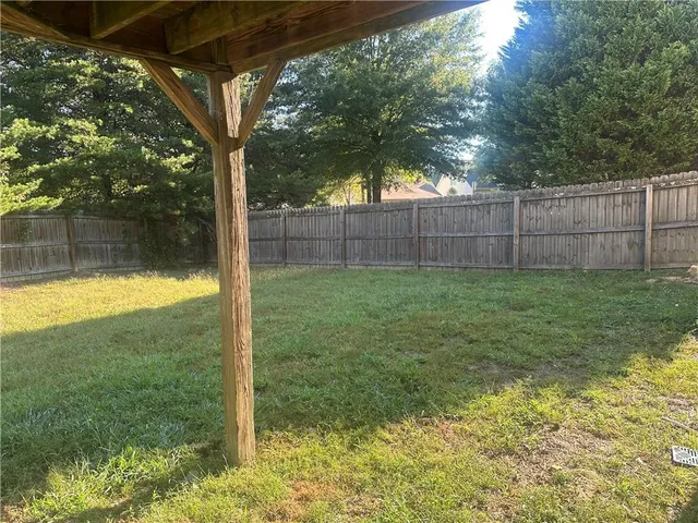 a view of a backyard with wooden fence