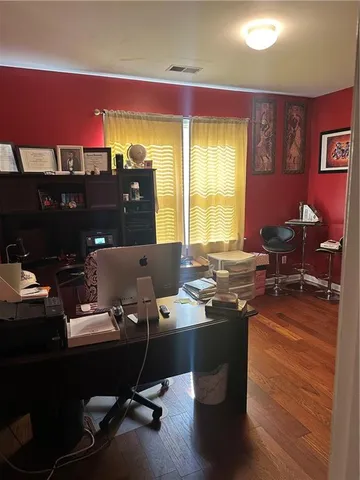 a view of a workspace with furniture and a window