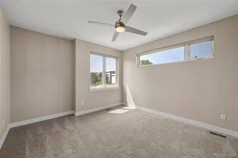 an empty room with closet and a ceiling fan