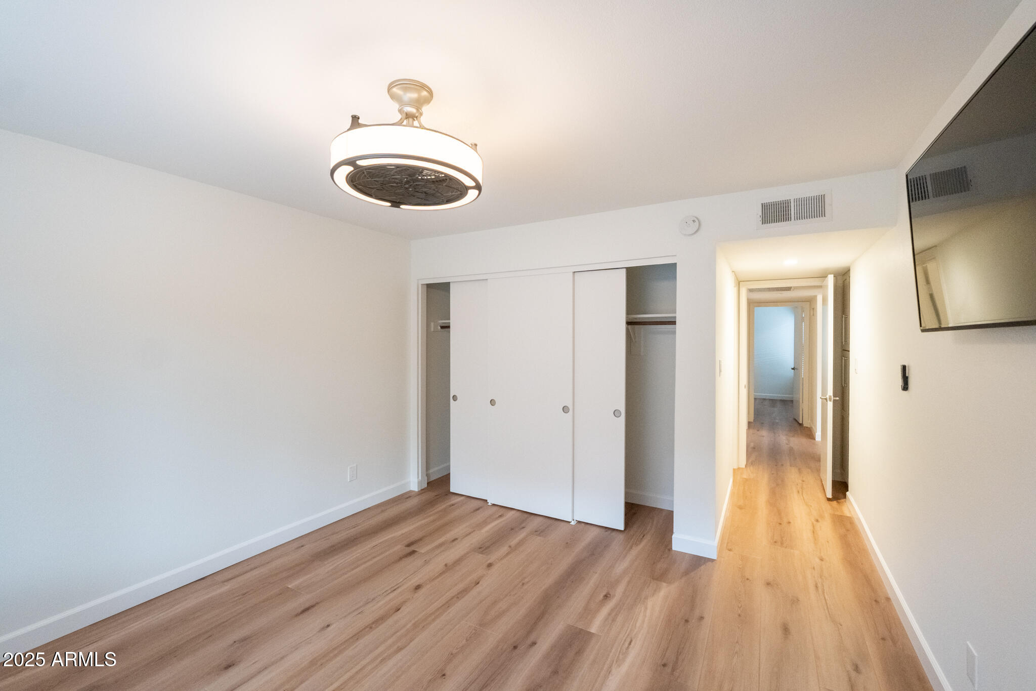 10115 East Mountain View Road, Unit 1089 Scottsdale, AZ 85258 - Photo 11 of 28 a view of a room with wooden floor and wall painting
