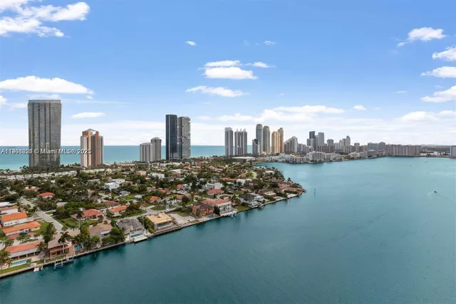 a hallway with wooden floor chandelier and windows