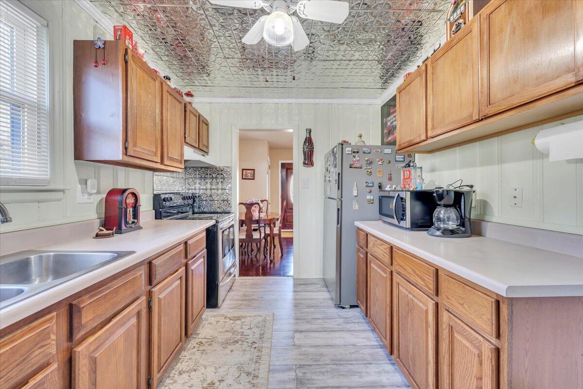 4820 Rutgers Street Northwest Roanoke, VA 24012 - Photo 14 of 41 a kitchen with stainless steel appliances granite countertop a sink dishwasher stove and refrigerator with wooden cabinets