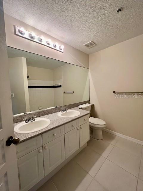 720 Celebration Avenue, Unit 235 Celebration, FL 34747 - Photo 12 of 16 a bathroom with a double vanity sink mirror and toilet