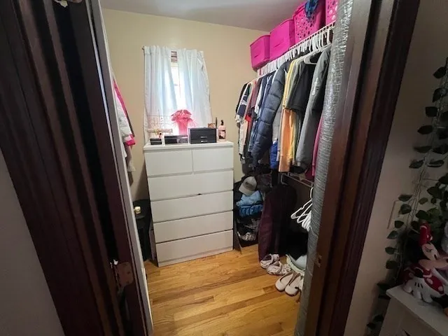 a view of walk in closet with clothes and shoes
