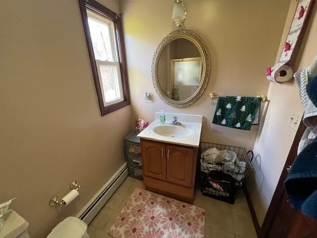 a bathroom with a toilet mirror vanity and a sink