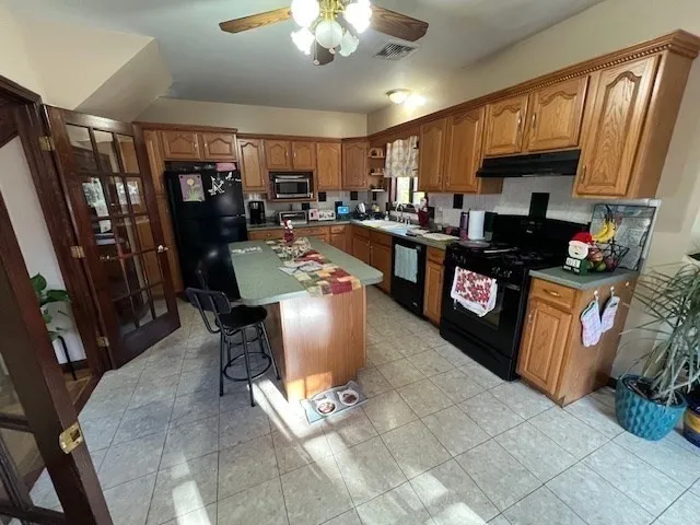 a kitchen with stainless steel appliances granite countertop a refrigerator a stove sink and cabinets