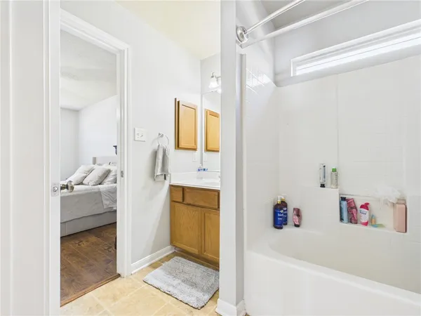 a bathroom with a tub sink and mirror