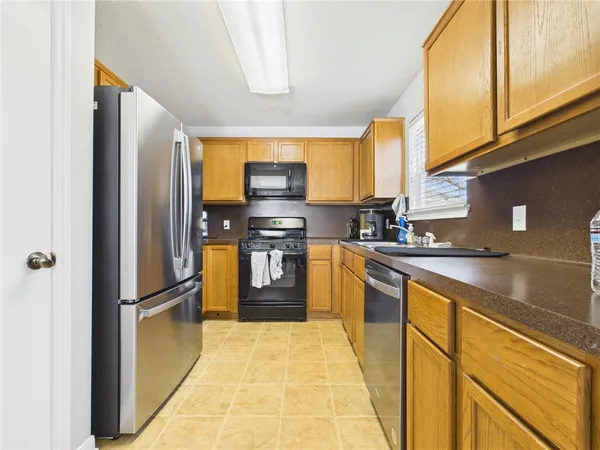 a kitchen with stainless steel appliances granite countertop a refrigerator sink and cabinets