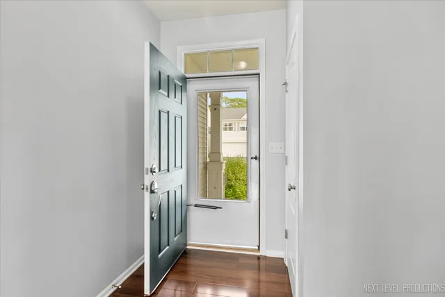 a view of a hallway with wooden floor and a window