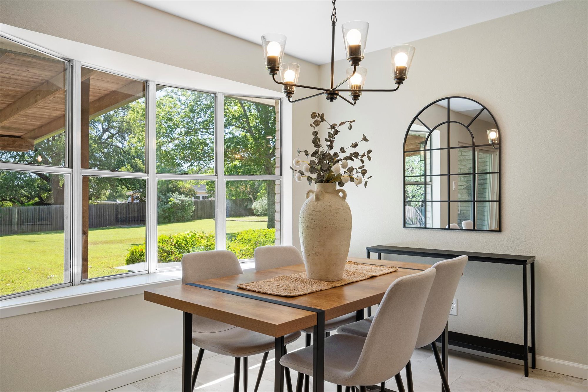 109 Woodland Road Georgetown, TX 78628 - Photo 18 of 40 Natural light floods this dining area, highlighting the polished tile floors and the serene views of the green backyard.