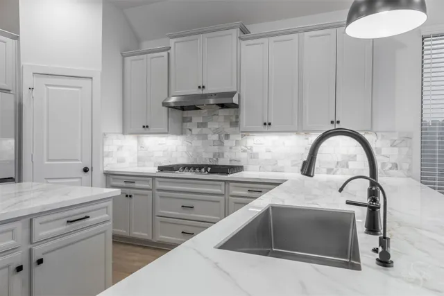 a kitchen with white cabinets a sink and dishwasher
