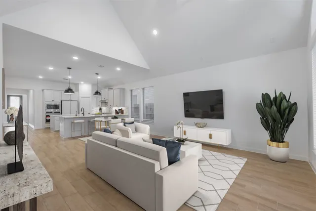 a living room with furniture a flat screen tv and a fireplace